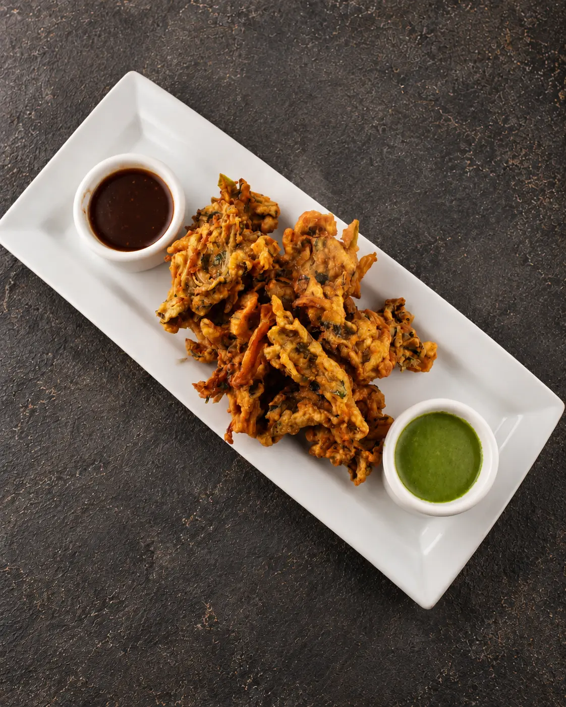 Mix Vegetable Pakora fritters served with tamarind and mint chutneys