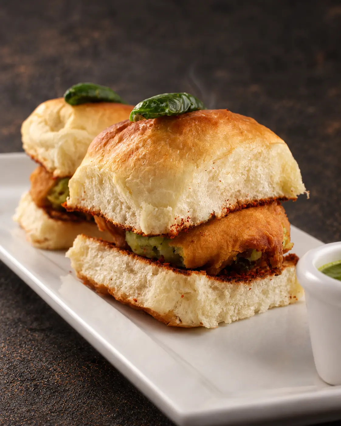 Two Vada Pav sliders filled with spiced potato fritters and chutney